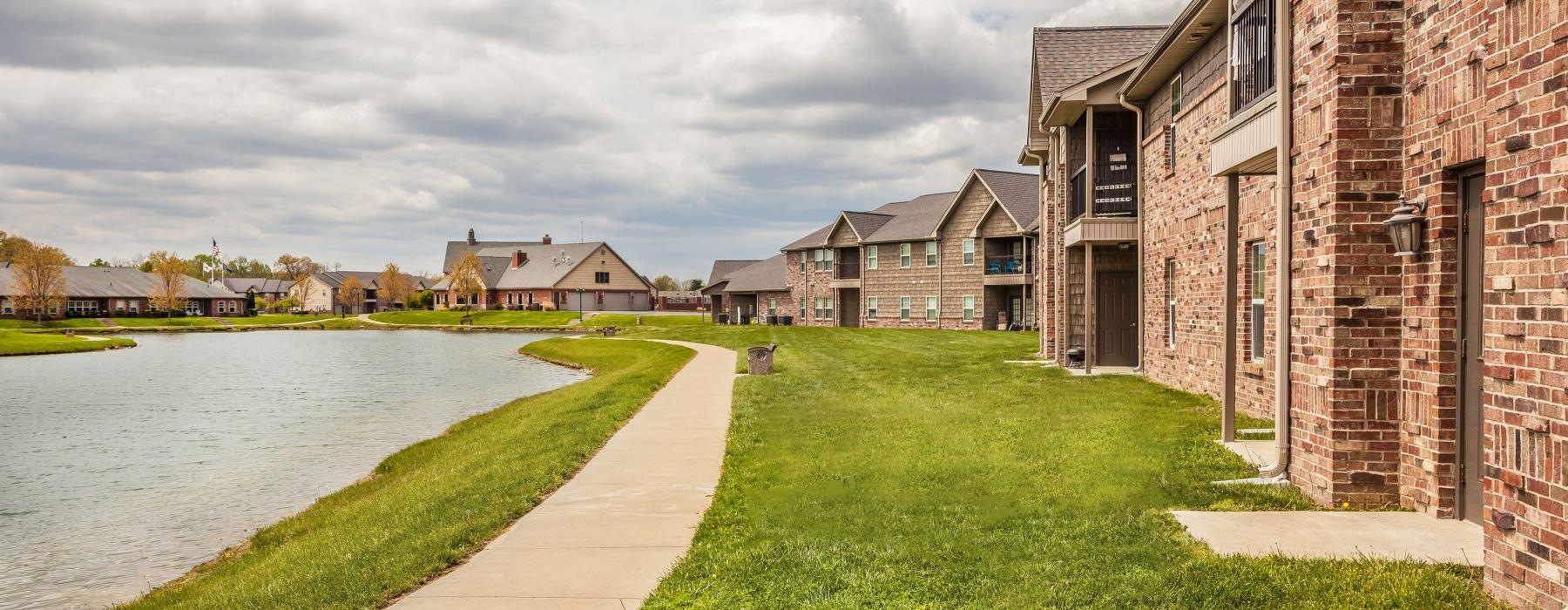a row of apartments next to a pond