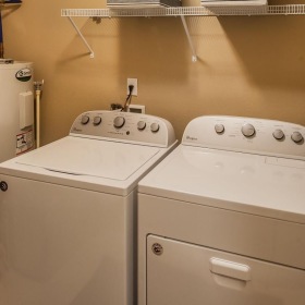 a washer and dryer in a room  by a how water heater