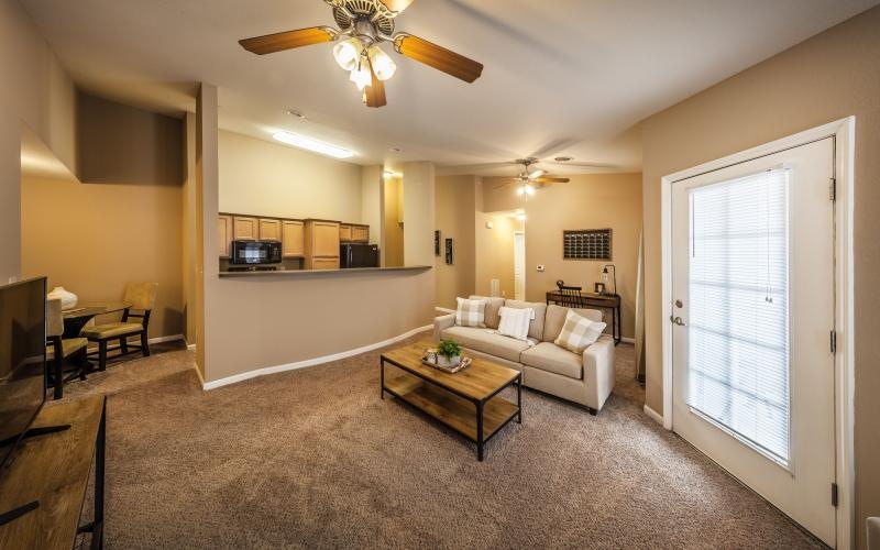 a living room with a ceiling fan couch and coffee table